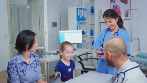 Doctor and Nurse Talking with Child Patient