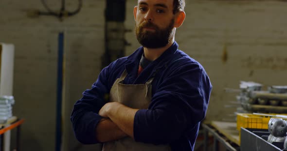 Metalsmith standing with arms crossed in workshop 4k