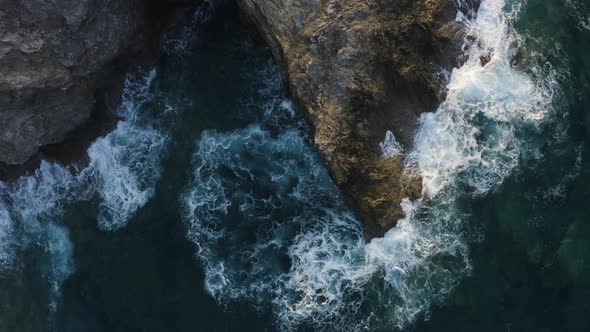 Flying Above Waves Crashing of Rocks. Aerial view of Turquoise Waves in the sea 