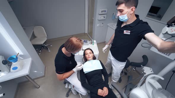 Doctor and patient in dentist office. Dentist treating teeth to woman patient in clinic