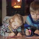 Brother and Sister Lying on the Floor in the Room Writing and Drawing Fireplace in the Background - VideoHive Item for Sale