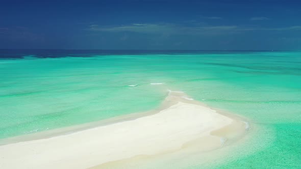 Wide above tourism shot of a white sandy paradise beach and blue ocean background in colourful 4K