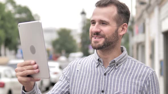 Outdoor Video Chat on Tablet By Beard Casual Man