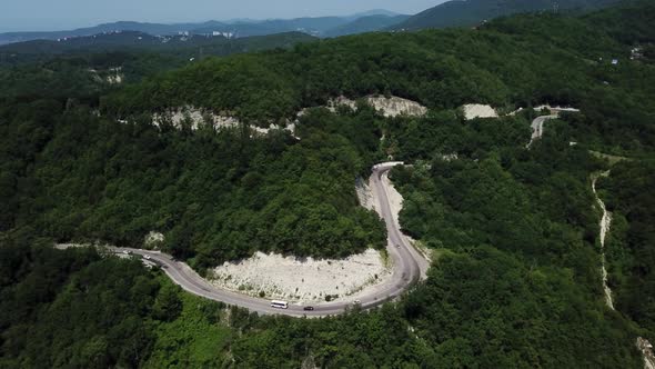 Aerial View From Above of Curve Road with a Car on the Mountain with Green Forest in Russia