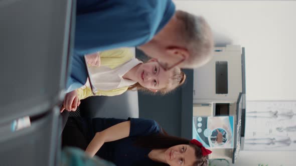 Vertical Video Health Specialist Talking to Small Child and Mother in Hospital Reception