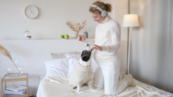 Happy Pregnant Woman Playing With Dog And Dancing In Headphones