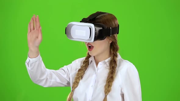 Girl in Virtual Reality Glasses Is Watching an Exciting Video Green Screen. Slow Motion