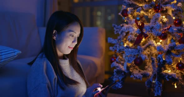 Woman use of mobile phone at Christmas decoration