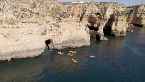 Group of people on kayak explore sea caves and cliffs of Ponta da Piedade, Lagos, Algarve