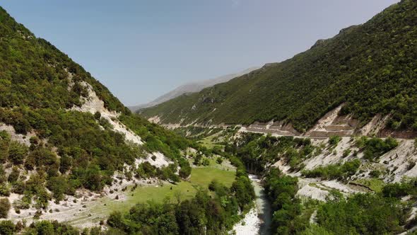 Aerial Drone Footage View Flight Over Mountain with Forests Fields and River in Sunrise Soft Light