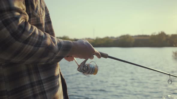 Young Fisherman Actively Fishing at Lake