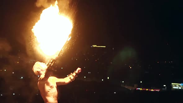 Young Blond Male Breathes Out Large Stream of Fire Making Fireball with Kerosene Spray Slow Motion