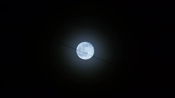 The Full Moon is Blue Against the Background of the Night Black Sky a Hanging Wire From Buildings