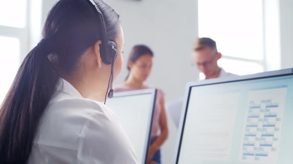 Diverse team of young professionals is working in the phone support office.