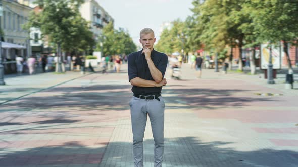 Zoomin Time Lapse of Pensive Guy in Elegant Clothing Standing Outside in Pedestrian Street