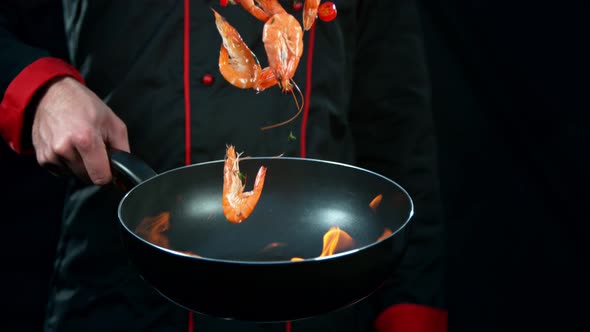 Super Slow Motion Shot of Chef Holding Frying Pan and Falling Shrimps Into Fire at 1000Fps