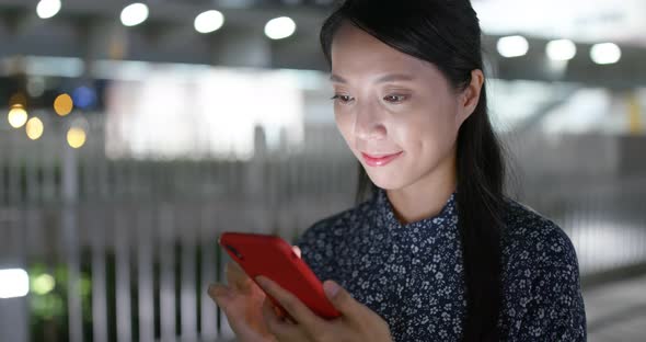 Woman read on smart phone in city at night