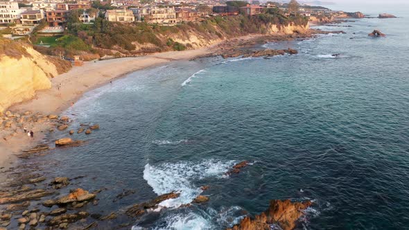 Flying over million dollar beach front luxury homes and the beautiful Laguna Beach California tide p