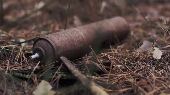 An Aerosol Can Lies on the Ground in a Rusty Forest