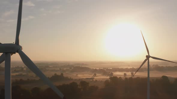 Drone Shot Closeup of Windmills Standing in a Field at Sunrise