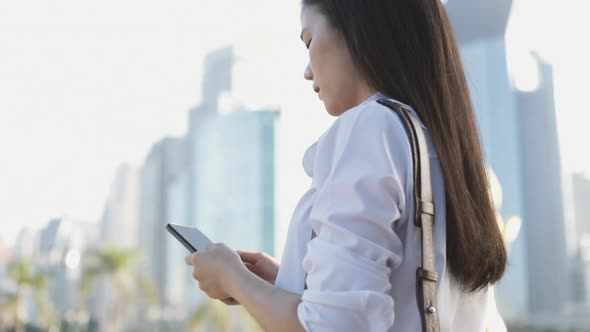 Close-up hands Asian businesswoman in a white shirt is using a smartphone texting sharing messages.