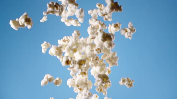  Falling popcorn, flying popcorn on blue background in slow motion