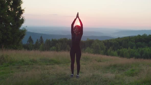 Relaxed Lovely Sporty Fit African American Woman Doing Yoga Sun Salutation Pose in Mountains at