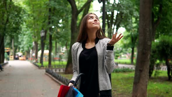 Portrait of a Young Attractive Brunette Woman with Her Colorful Umbrella in Her Hands Checking If It