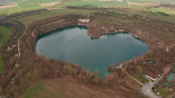 Backwards Reveal Surroundings of Natural Heart Shaped Lake in Countryside