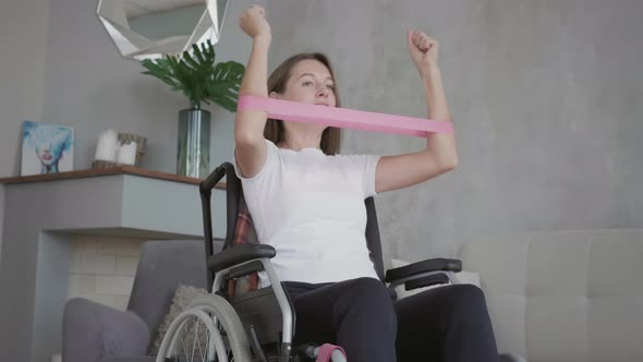 Woman in wheelchair is exercising at home