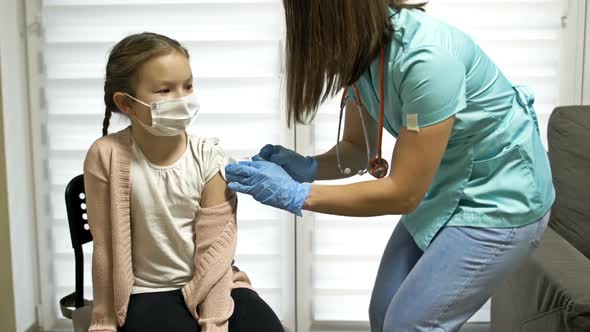 Female Nurse in Protective Uniform and Medical Mask Making Covid19 Vaccine Injection to Girl 78