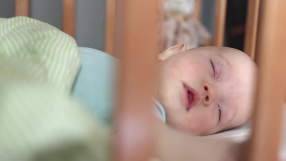 Portrait of Sleeping Infant Baby in Crib Caucasian Child Kid is Lying in Bed