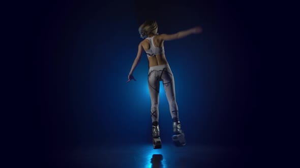 Attractive Girl Dancing Against Blue Spotlight at Studio