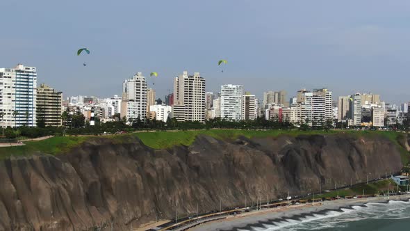 Paragliders flying like birds over the coastline of the Lima capital city, in Peru, the Miraflores d