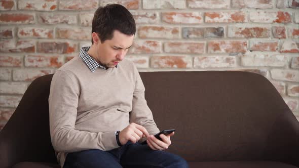 Man Spending Time with Cellphone When Waiting in Lobby