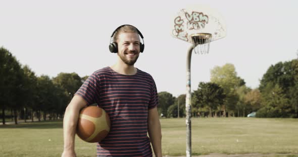 Man on basketball court listening to music