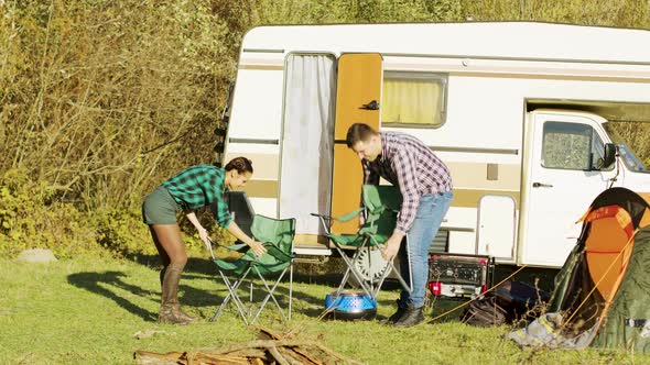 Relaxed Couple Setting Up Their Camping Chairs