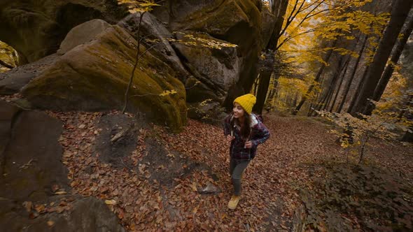 Slow Motion Wide Angle View Girl Traveler Hikes in Woods with Yellow Foliage in Ukraine