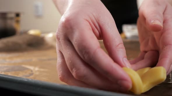 Closeup of Woman's Hands Spreading Dough Mold on Baking Sheet