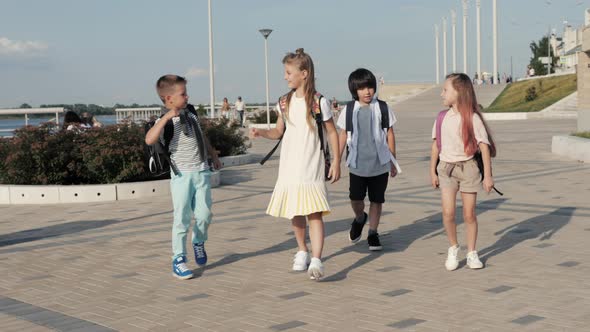 Infant School Kids Walking To School with Backpacks and Give High Five To Eachother.