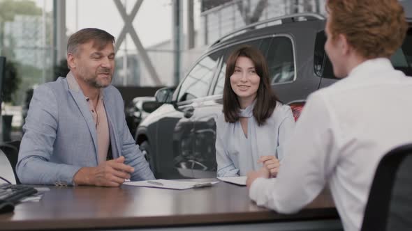 Happy Couple Purchasing Car in Dealership