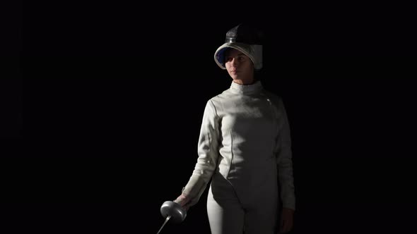 Portrait of Young Woman Fencer Saluting with Rapier As Sign of Greeting Putting on Helmet and
