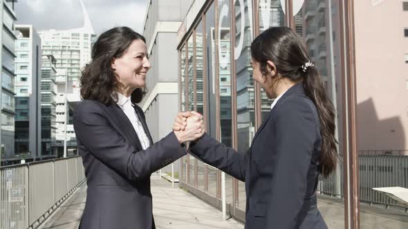 Businesswomen Shaking Hands and Talking on Street