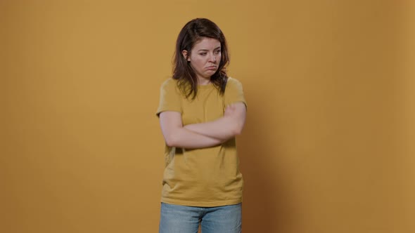 Seriously Upset Woman with Arms Crossed Feeling Sad and Disappointed Looking Grumpy Mumbling