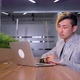 a Young Asian Manager is Working in an Office with a Laptop - VideoHive Item for Sale