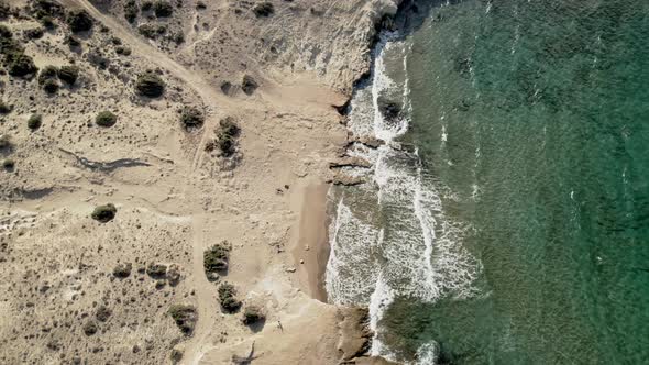 Turquoise blue waves gently roll onto a sandy Mediterranean coastline. Crystal-clear water summertim