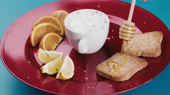 Honey is Falling Onto Rusks for a Restaurant Breakfast Plate