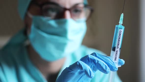 Conceptual video of a doctor holding a syringe with the coronavirus COVID-19 vaccine.