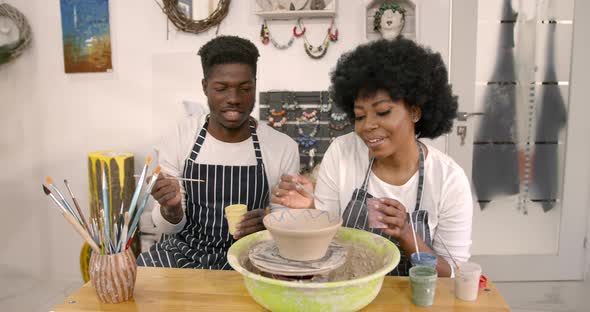 Black Couple Decorating Plate in Workshop During Class