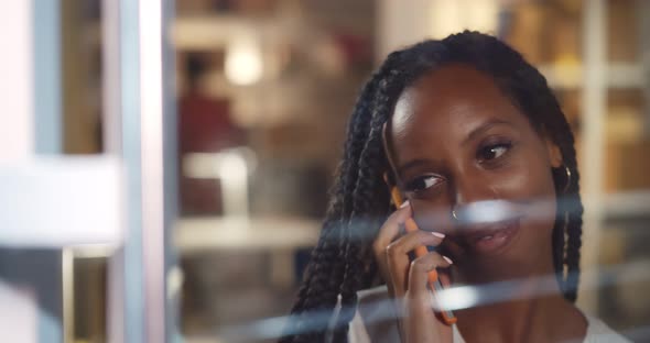 Young Afro Woman Standing Near Office Window Having Phone Call